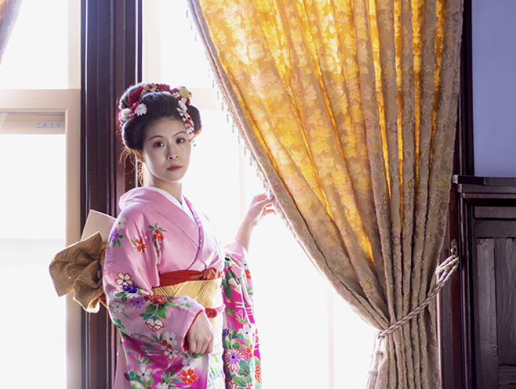 窓辺で着物姿を楽しむ女性